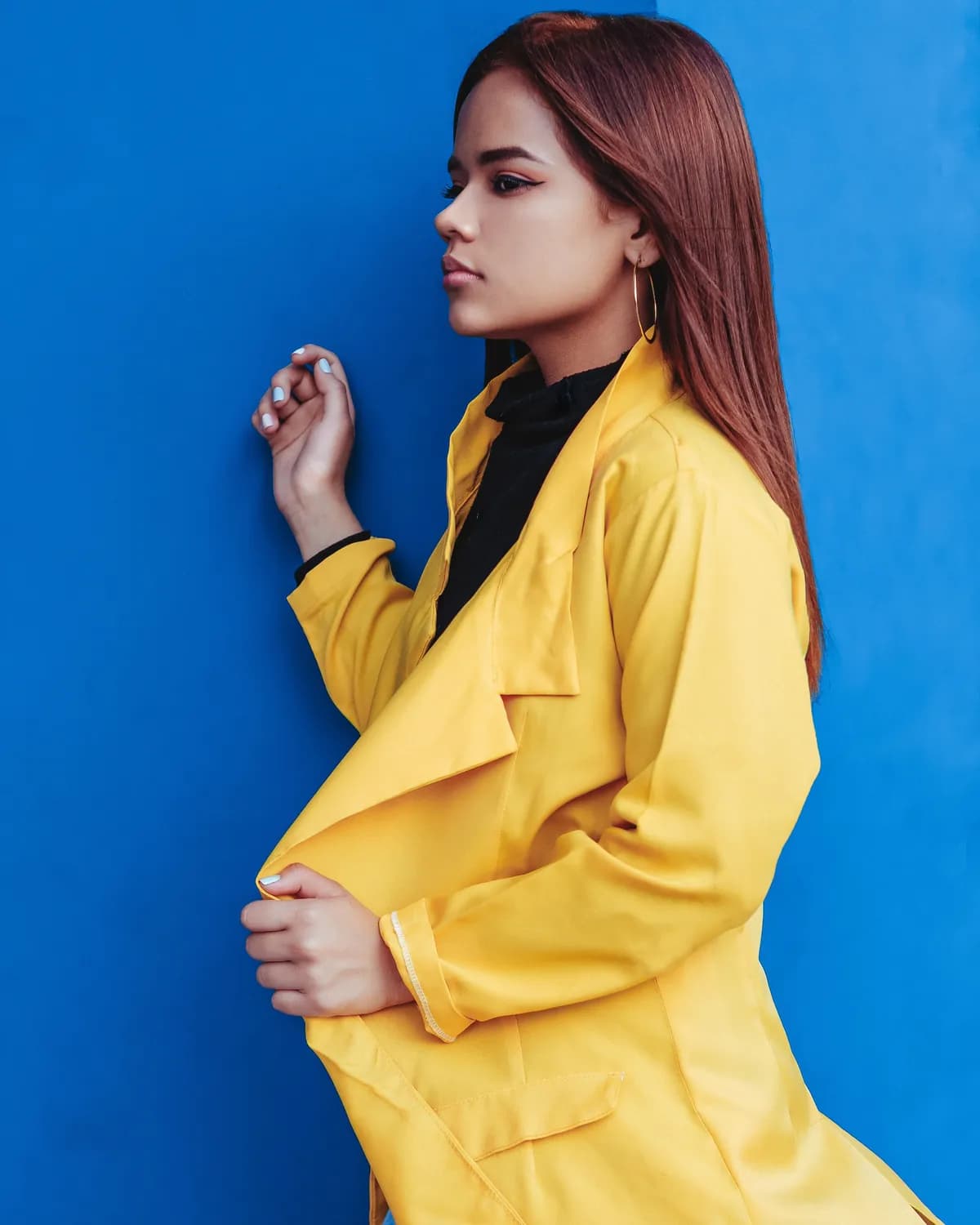 Modelo de casaco amarelo contra fundo azul